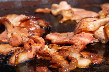 Closeup image of a cooking bacon on a barbecue at a school fundraiser on election day in Australiaの写真素材