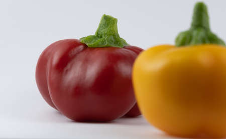 Closeup image of red and yellow capsicums on a white backgroundの写真素材