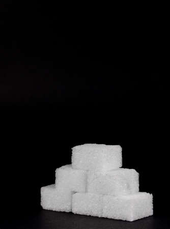 Pyramid of white sugar cubes isolated against a black backgroundの写真素材