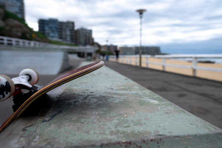 Close up of skateboard leaning against an obstacle at a beachside skate park.