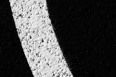 Close up image of newly painted white lines on asphalt