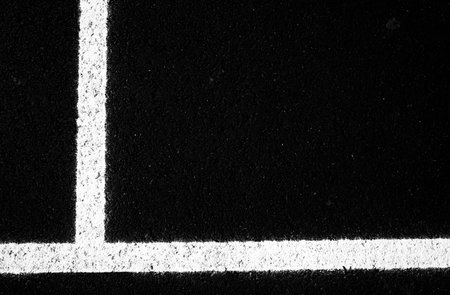 Close up image of newly painted white lines on asphalt
