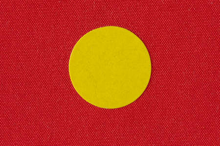 Macro image a yellow sticker on the texture of a red book coverの写真素材