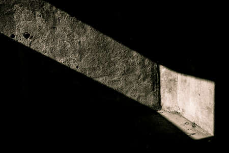 A single light ray on the wall of an empty concrete bunkerの写真素材