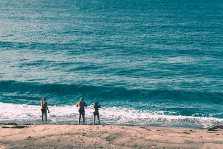 NEWCASTLE, AUSTRALIA - June 16 2019 two men and a lady preparing to take a morning swim in the Pacific Oceanのeditorial素材