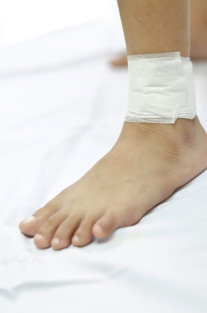 Ankle of kid wrapped in white bandages