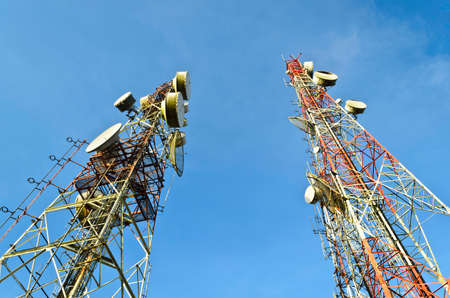 Telecommunication tower with antennas over blue sky の写真素材