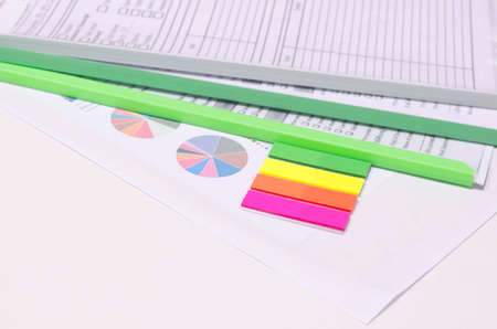 Colorful note pad with graphs and document files on tableの写真素材