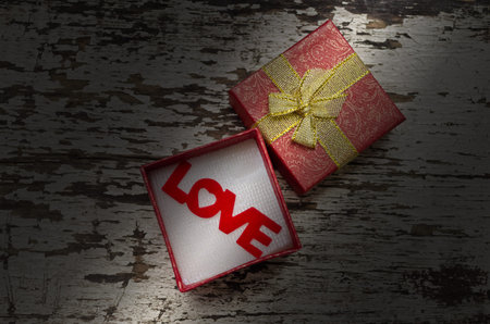 Love alphabet in gift box on grunge wood background