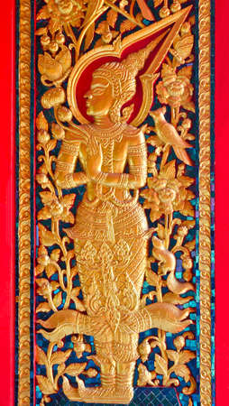 Thai style angel sculpter at temple door in Thailandの写真素材