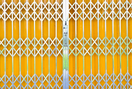 Yellow metal grille sliding door with pad lock and aluminum handleの写真素材