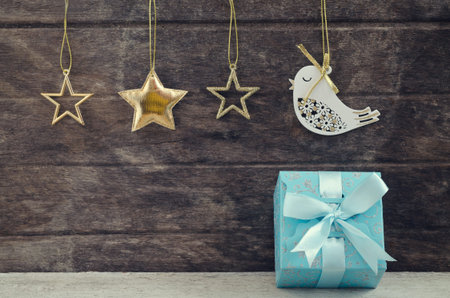 blue gift bow with ornaments hanging  over woodenの写真素材