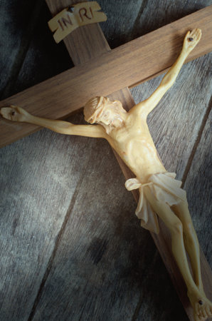A carved statue of the Crucifixion of Jesus Christ on wood background in vintage style