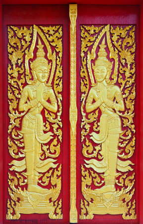 golden angle sculpture at Thai public temple doorの写真素材