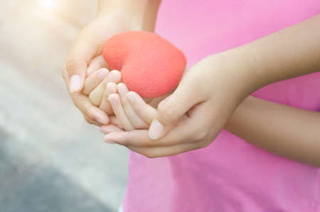 Soft focus of adult and child hands holding heartの写真素材