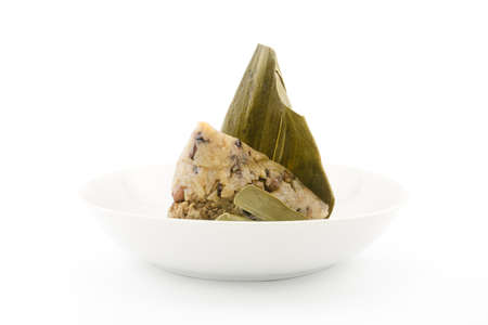 Traditional wrapped rice dumplings or zongzi on a plate, isolated on white backgroundの写真素材