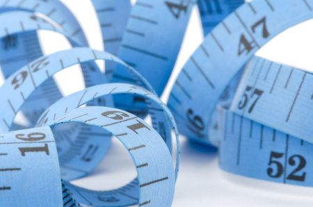 Close up of blue measuring tape for health concept, isolated on white background