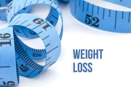 Weight loss, health concept, close up & selective focus of blue measuring tape, isolated on white backgroundの写真素材