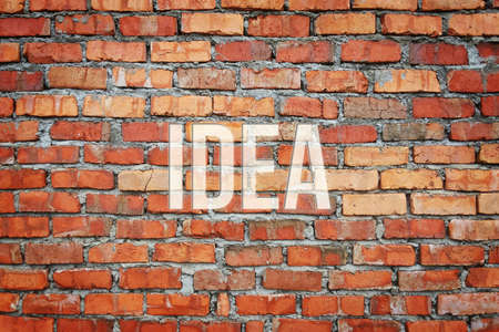 Idea, business concept words, with red brick tiled walls as background for web page, graphic design, catalog or wallpaper.の写真素材