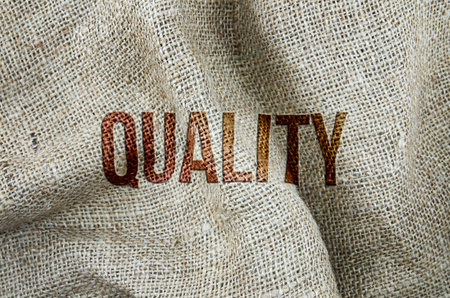 Quality, business embossed conceptual words, with gunny sack or shoe cloth as background for web page, graphic design, catalog or wallpaper.の写真素材