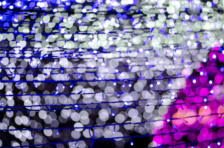 Abstract colorful blur bokeh fairy light festival, city street light defocused at night, dark...