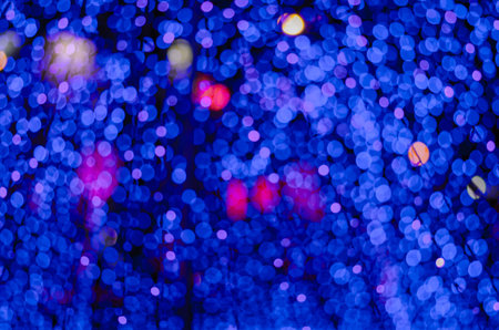 Abstract colorful blur bokeh fairy light festival, city street light defocused at night, dark...