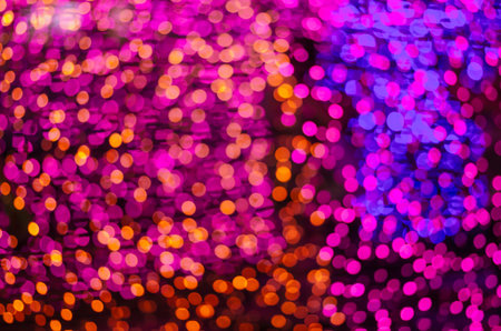 Abstract colorful blur bokeh fairy light festival, city street light defocused at night, dark...