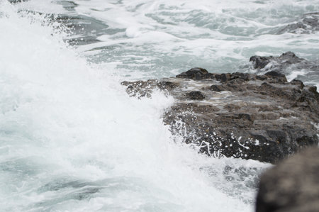 Waves crashing against rocks at the Giant's Causeway, Northern Ireland.