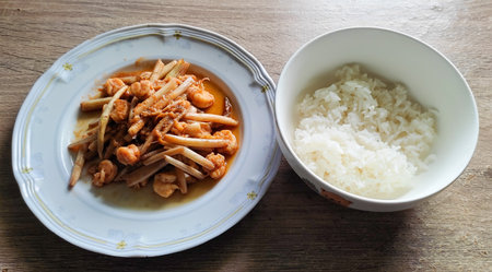 Stir-fried Lai Bua with shrimp in a white dish Place it with rice in a white cup. On the wooden table top view: Asian stir-fry dish, fresh vegetables and shrimp, sweet, crispy, delicious, mellow, suitの写真素材