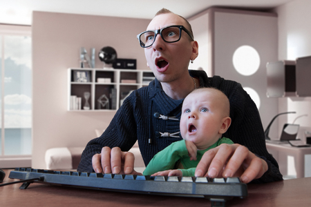 Father and son surprised looking to the screen and keeping mouth openの写真素材