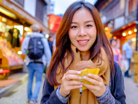 Young Asian tourist in Japan with Japanese dessert - Dorayaki.の写真素材