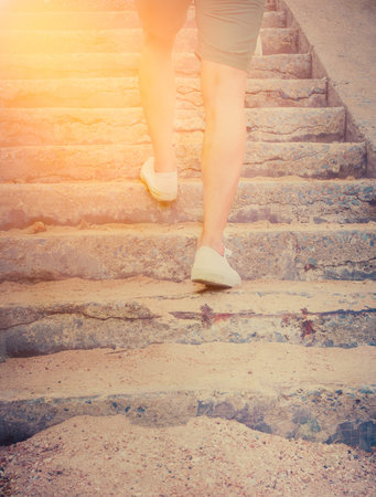 Close-up Man with sneaker shoes running on the step. International sun light and vintage tone.