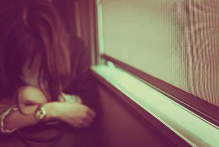 Blurry sleeping young lady on train, closed eyes, black hair with blurred lights in corner. Vintage tone and Selective focus.の写真素材