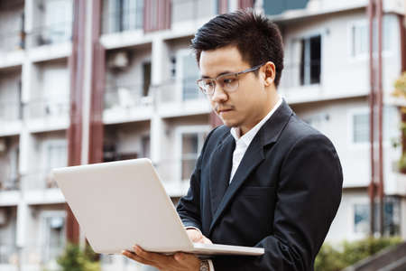 Handsome asian Business man working on property investment with laptop.の写真素材
