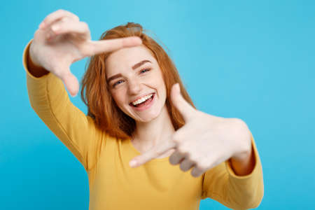 Close up Portrait young beautiful attractive redhair girl smiling looking at camera. Blue Pastel Background.の写真素材