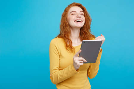 Close up Portrait young beautiful attractive redhair girl happy smiling on digital table with wining something. Blue Pastel Background. Copy space.の写真素材