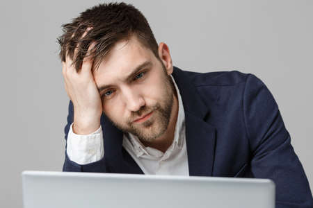 Business Concept - Portrait handsome serious business man in suit looking at laptop. White Background.の写真素材