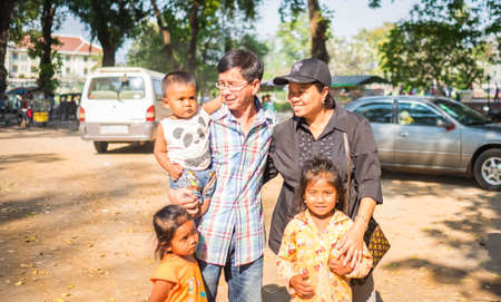 CAMBODIA - FEBUARY 18,2017 : Unidentified Asian tourist holding and playing with poverty children in Cambodia. A lot of poverty kids in Cambodia begging for money on roadside.のeditorial素材