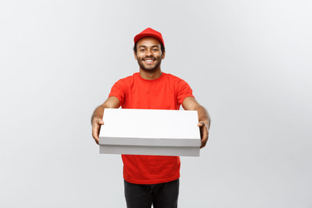 Delivery Concept - Portrait of Handsome African American Pizza delivery man. Isolated on Grey studio...