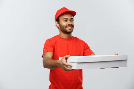 Delivery Concept - Portrait of Handsome African American Pizza delivery man. Isolated on Grey studio Background. Copy Space.の写真素材