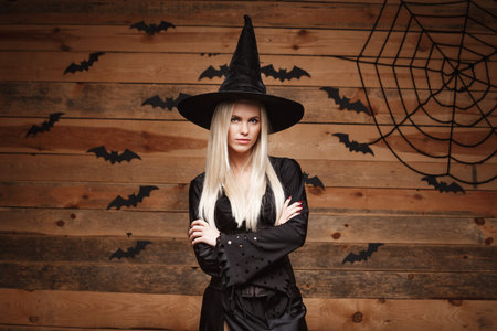 Halloween witch concept - Happy Halloween Sexy Witch holding crossing arms posing over old wooden...