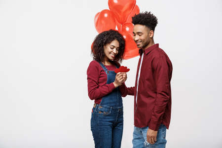 Portrait of young couple in love holding red paper heart and balloon.の写真素材