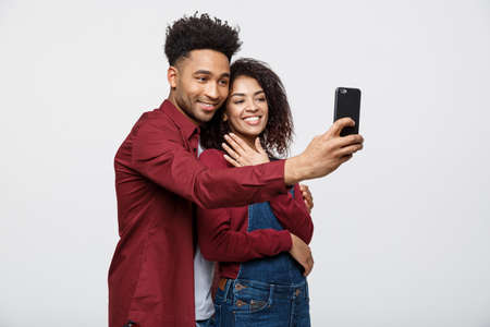 Young attractive African American Couple Pose For selfie pose with smart phoneの写真素材