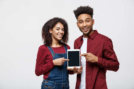 Portrait of African American couple holding table with happy expression on white backgroundの写真素材