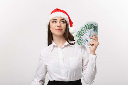 Christmas and Financial concept - Young confident business woman showing money in front of her with happy face.の写真素材