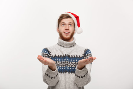 Christmas Concept - young cool beard man in sweater with waiting for snow gesture.