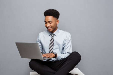 Business Concept - Happy handsome professional african american businessman enjoy playing on labtop.の写真素材