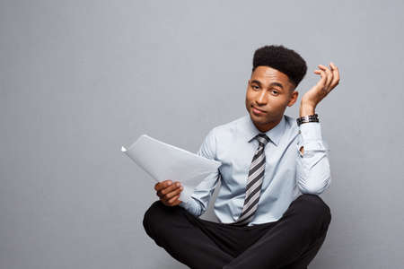 Business Concept - handsome young professional african american businessman serious reading paperworks.の写真素材