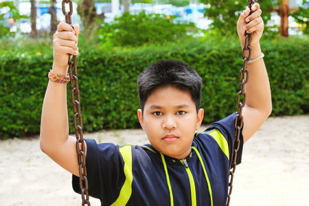 Happy asian sport boy play on swing playground in Garden.の写真素材