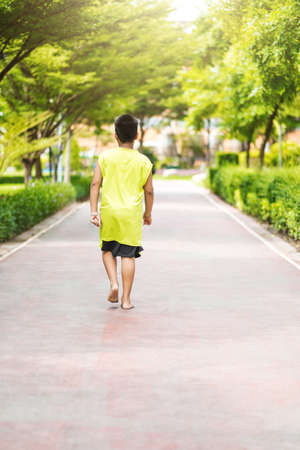 Rare view of young asian boy run in garden.の写真素材